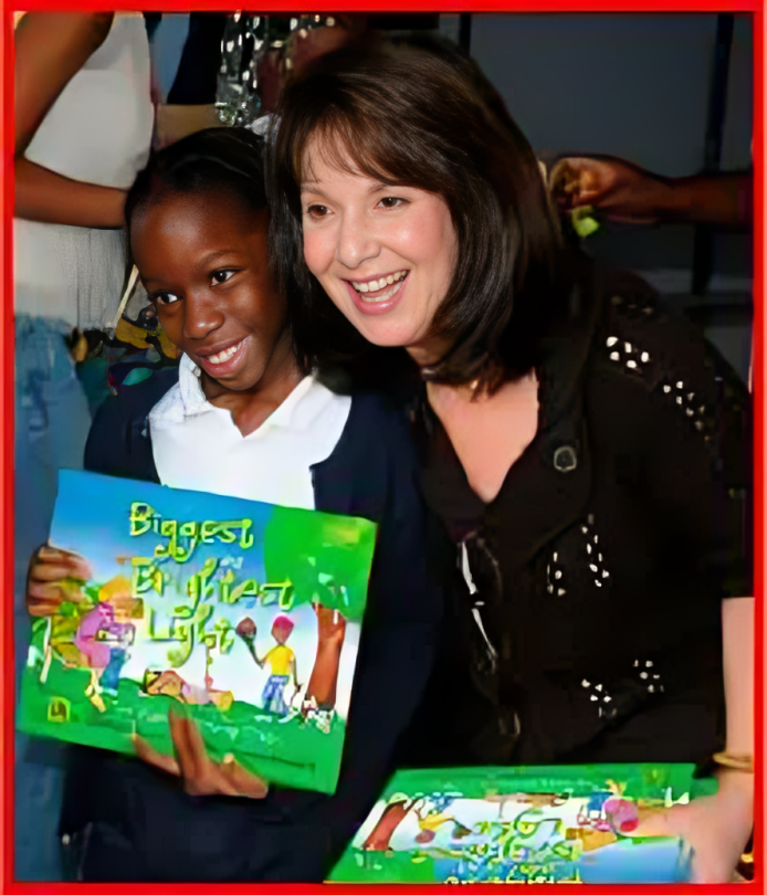 A woman and child holding books in front of them.