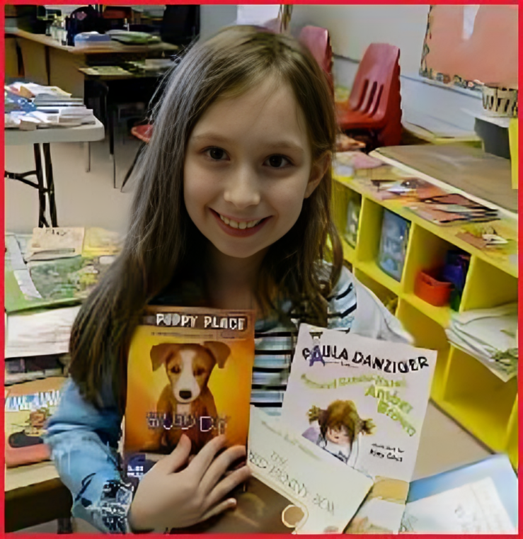 A girl holding two books in her hands.