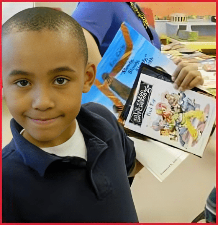 A boy holding up an item in his hand.