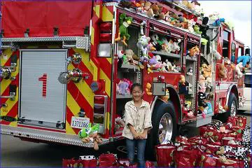 A woman standing in front of a fire truck.