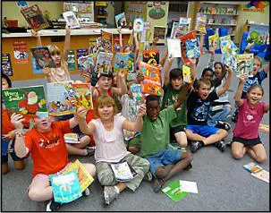 A group of children sitting on the floor holding books.