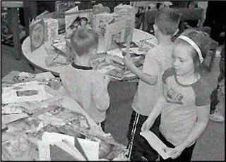 A group of children standing around a table.